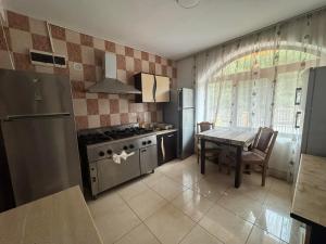 a kitchen with a table and a stove and a refrigerator at Casa Lupascu in Vatra Dornei +65 photos