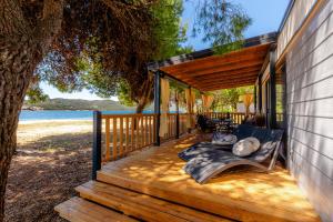 a wooden deck with a bench on the beach at Mobile Homes Camp Perna - Adriatic Kampovi in Orebić +137 photos