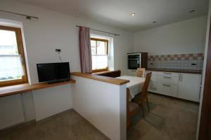 una cocina con mesa y TV. en Hilpoldhof, en Castelrotto 8 fotos más