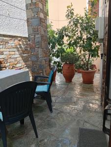 a patio with a table and chairs and potted plants at Irida mariaSmall studio in Agios Ioannis Pelio +4 photos