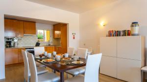 a kitchen and dining room with a table and white refrigerator at Clube Alvor Ria - Prime Residence in Alvor