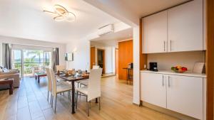 a kitchen and dining room with a table and chairs at Clube Alvor Ria - Prime Residence in Alvor +35 photos