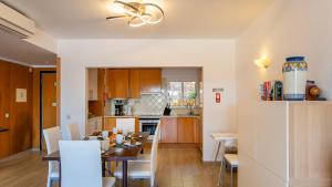 a kitchen and dining room with a table and chairs at Clube Alvor Ria - Prime Residence in Alvor