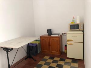 a small kitchen with a table and a refrigerator at Casa l'àvia - Sant Pol de Mar in San Pol de Mar +23 photos