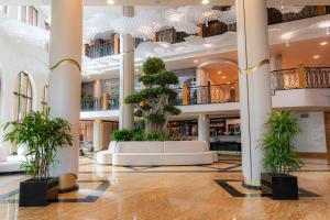 a lobby with a tree in the middle of a building at Admiral Hotel - Ultra All Inclusive & Private Beach in Golden Sands +109 photos