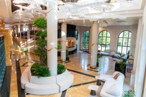 a lobby of a building with columns and plants at Admiral Hotel - Ultra All Inclusive & Private Beach in Golden Sands