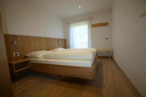 una cama grande en una habitación con ventana en Hilpoldhof, en Castelrotto