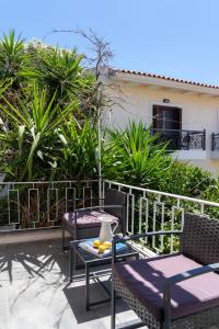 a patio with two chairs and a table with fruit on it at Australia in Skiathos