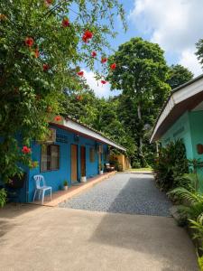 a blue building with a chair in front of it at Hornbills Garden in Khlaung Phai Bae