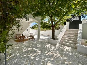 a patio with a tree and a table and stairs at Bianco e Rosmarino in Selva di Fasano