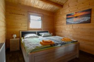 a bedroom with a bed in a wooden cabin at Waldsiedlung - Haus 13 in Großkoschen +2 photos