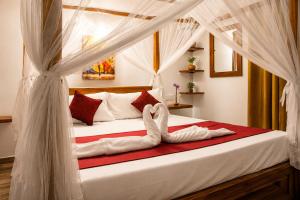 a bedroom with a bed with white curtains at Villa Serene Herbs Dickwella in Dickwella