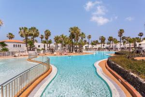 a swimming pool at a resort with palm trees at Oasis Duna _ Estrella Del Mar Pool in Corralejo