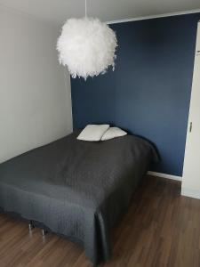 a bedroom with a bed and a blue wall at Apartment in Raahe