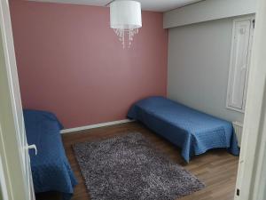 a bedroom with two beds and a chandelier at Apartment in Raahe