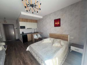 a bedroom with a large bed and a kitchen at Gio apartment in Angisa