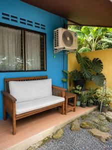 a bench sitting in front of a blue wall at Hornbills Garden in Khlaung Phai Bae