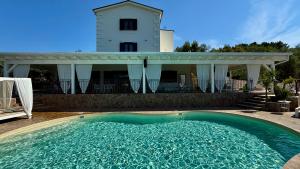 a swimming pool in front of a house at B&B Borgo del Nespolo in Peschici