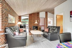 a living room with two leather chairs and a table at Skovvang 80 in Nørre Nebel