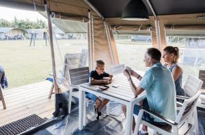 a family sitting at a table in a camper van at Camping Begur - Luxe Lodge in Begur