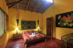 a bedroom with a bed in a room with two lamps at Hotel La Palapa Eco Lodge Resort in Portalón