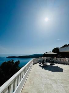 a patio with an umbrella and chairs and the water at Budva Sky Sea - View Point in Budva
