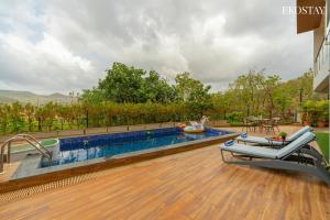 a swimming pool on a wooden deck with at EKOSTAY - Amani Villa in Khopoli