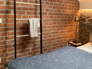 a bedroom with a brick wall and a bed at Stilvolles Wellnes-Refugium mit Privatsauna, Whirlwanne & Kamin im historischen Gut in Großharthau