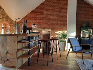 a kitchen with a counter and chairs and a brick wall at Stilvolles Wellnes-Refugium mit Privatsauna, Whirlwanne & Kamin im historischen Gut in Großharthau