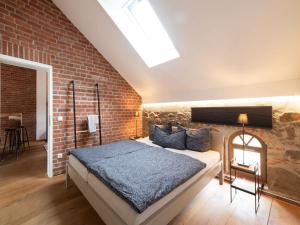a bedroom with a bed and a brick wall at Stilvolles Wellnes-Refugium mit Privatsauna, Whirlwanne & Kamin im historischen Gut in Großharthau