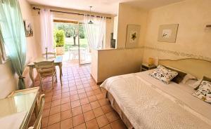 a bedroom with a bed and a table and a window at La Résidence du Moulin in Tourrettes-sur-Loup +150 photos
