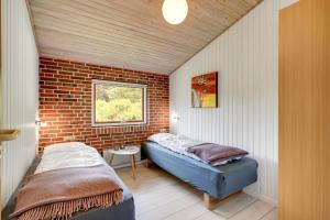 a bedroom with a bed and a brick wall at Skovvang 80 in Nørre Nebel