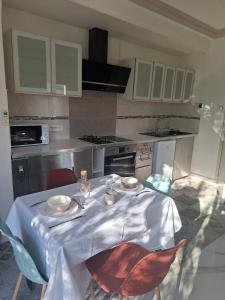a kitchen with a table with chairs and a white table cloth at comfortable studio in Grasse