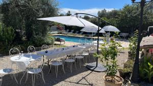 a group of tables and chairs next to a pool at comfortable studio in Grasse
