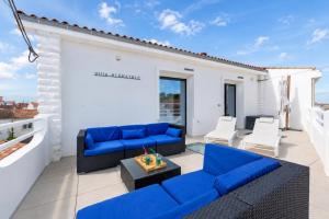 a patio with blue couches and chairs on a balcony at Villa Alekatele in La Tranche-sur-Mer