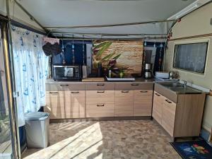an interior view of a kitchen in an rv at Comtesse-Camping Plauer See in Brandenburg an der Havel +16 photos