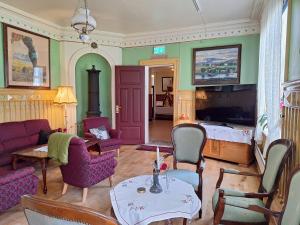 a living room with a couch and a table and chairs at Tjøtta Gjestegaard in Alstahaug