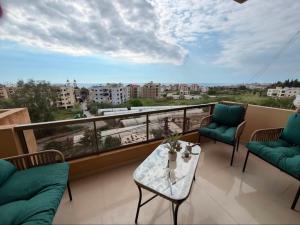 a balcony with a table and chairs and a view of a city at Batroun sunset guesthouse in Batroûn