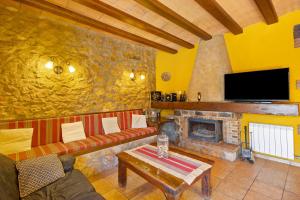 a living room with a couch and a fireplace at Casa Rural Ca La Siona in Avinyonet