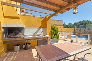 an outdoor patio with a table and a fireplace at Casa Rural Ca La Siona in Avinyonet