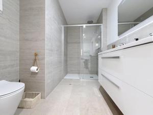 a white bathroom with a shower and a toilet at Les Villas de l'Ill in Didenheim +26 photos