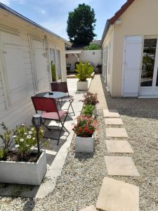 a patio with a table and some potted plants at Le Chalet in Ouistreham