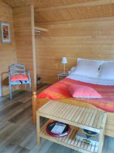 a bedroom with a bed and a table and a chair at Le Chalet in Ouistreham