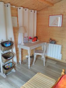 a desk in a wooden room with a table at Le Chalet in Ouistreham