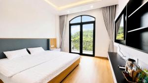 a bedroom with a large bed and a large window at The Muse Hotel 3 in Ðố Sơn