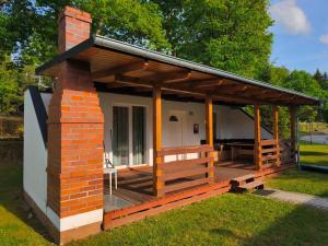 a small house with a porch and a deck at Domek Łagów Lubuski in Łagów