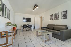 a living room with a couch and a table at Le Jardin de l'Atrium - Appartement moderne proche de Genève et Palexpo in Saint-Julien-en-Genevois