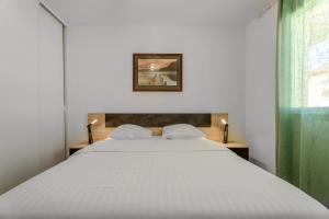 a bedroom with a large white bed and a window at Le Jardin de l'Atrium - Appartement moderne proche de Genève et Palexpo in Saint-Julien-en-Genevois