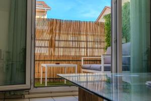 a balcony with a glass table and a fence at Le Jardin de l'Atrium - Appartement moderne proche de Genève et Palexpo in Saint-Julien-en-Genevois