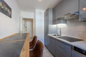 a kitchen with a sink and a wooden counter top at Le Jardin de l'Atrium - Appartement moderne proche de Genève et Palexpo in Saint-Julien-en-Genevois +8 photos